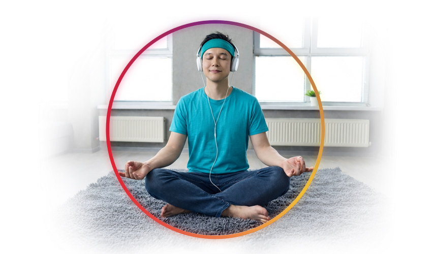 a woman meditating on a yoga mat with headphones on