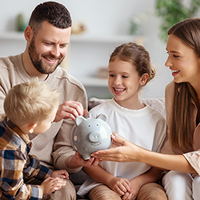 a family putting money in a piggy bank