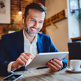 a businessman looking at his tablet at a coffee shop